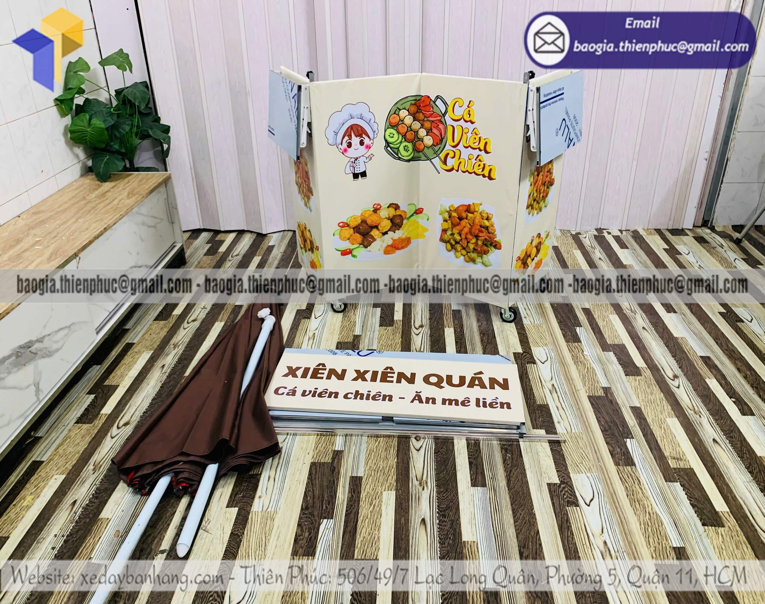 Quầy bán đồ ăn vặt hàng rong xếp gọn có dù che trước rạp phim bến xe